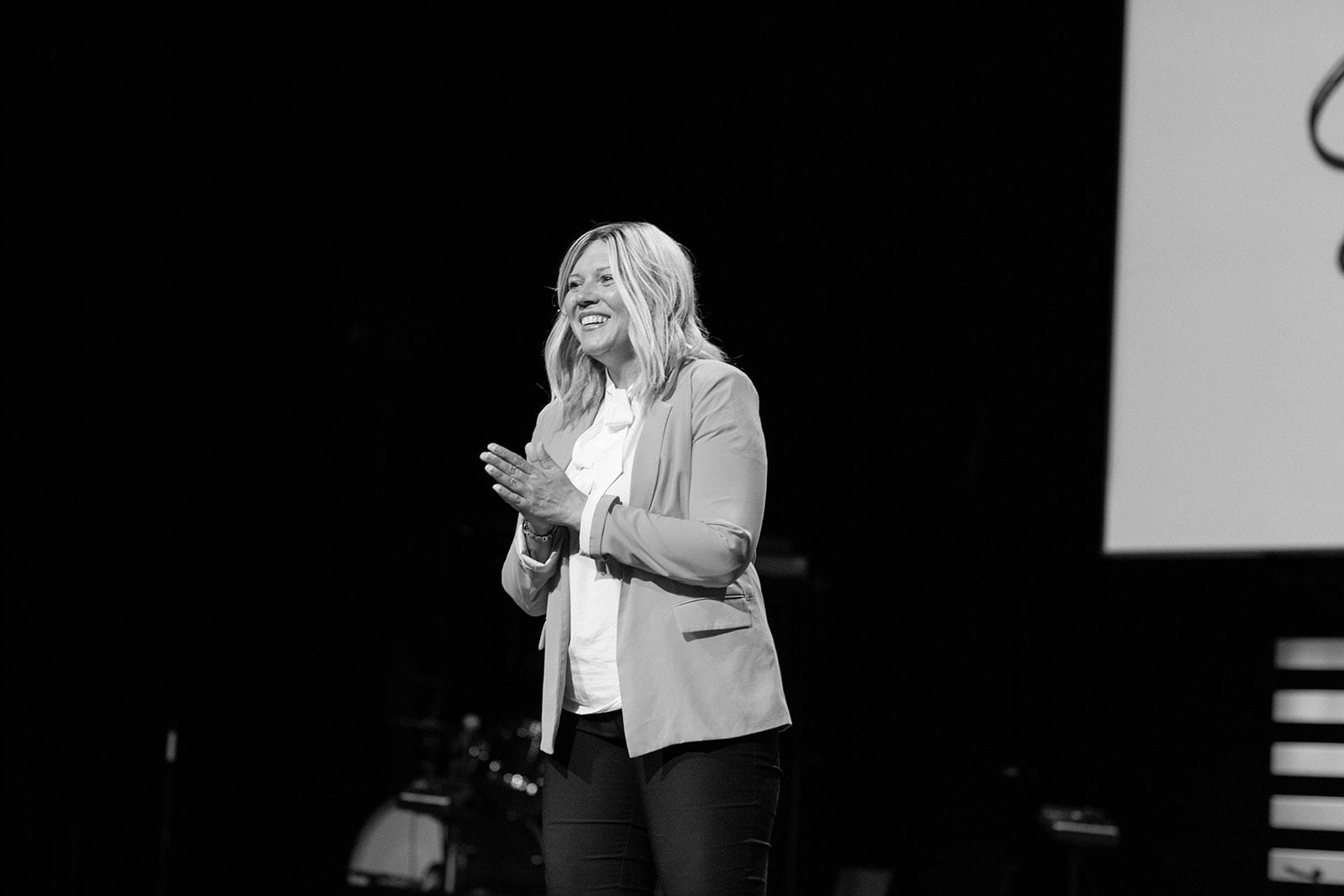 Jenn Gray smiling on stage while speaking